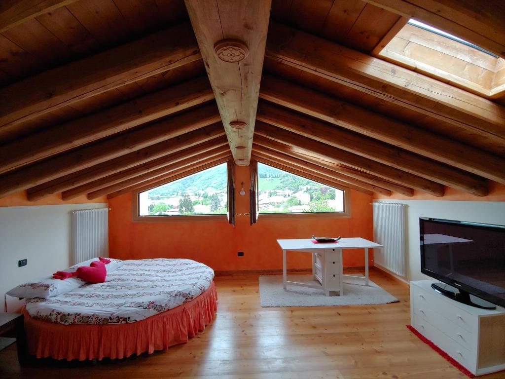 een slaapkamer met oranje muren en een bed met een televisie bij Casa Dolce Casa in Valdobbiadene
