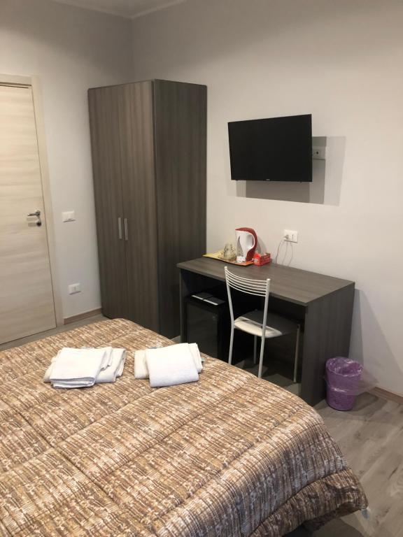 a bedroom with a bed and a desk and a television at Room 14 in Rome