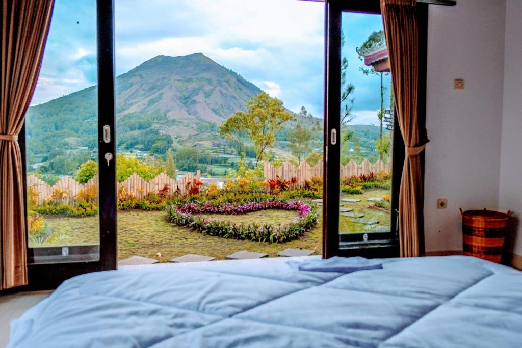 una camera da letto con una grande finestra con vista su una montagna di Bunbulan Panorama a Kintamani