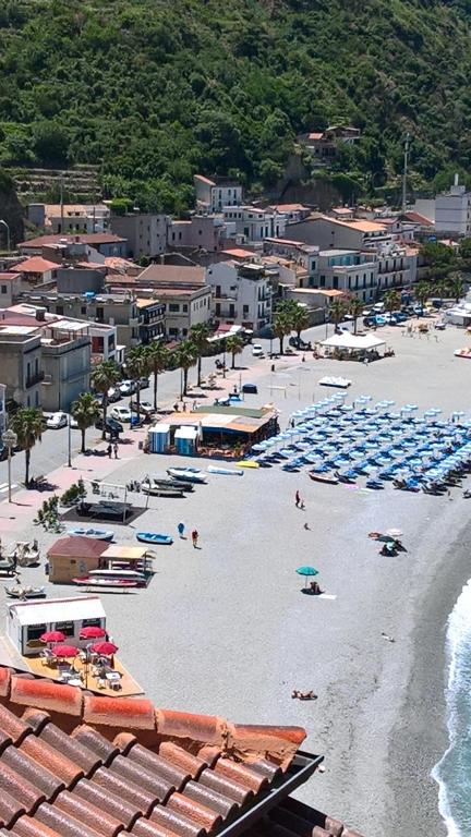 a beach with blue umbrellas and people on the sand at Stop And Go in Scilla