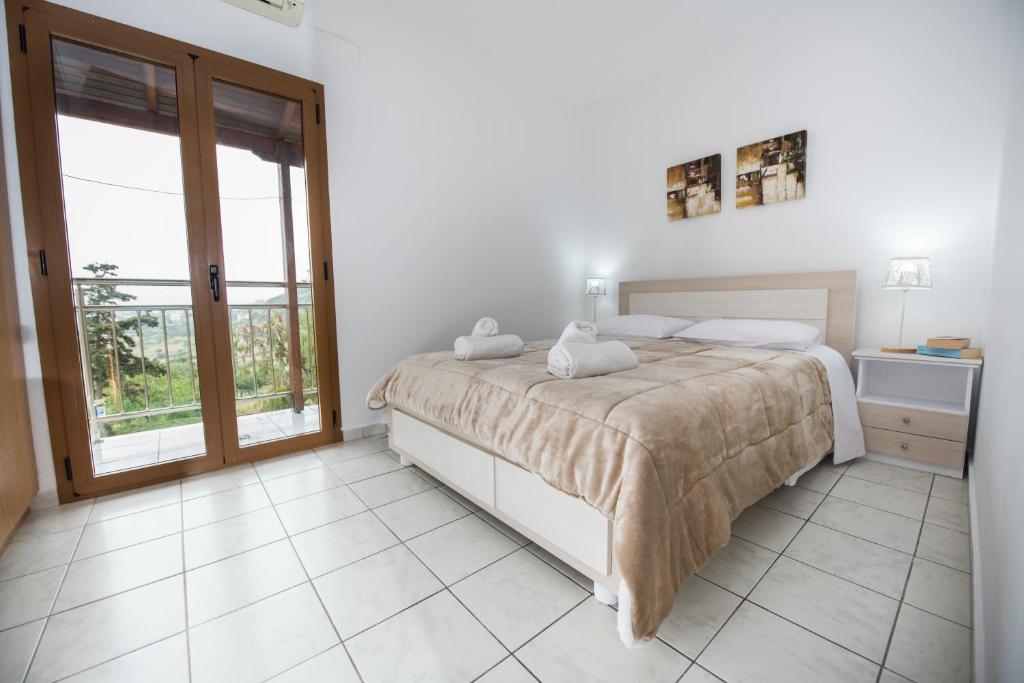 a bedroom with a bed and a large window at Irene Komos in Pitsidia