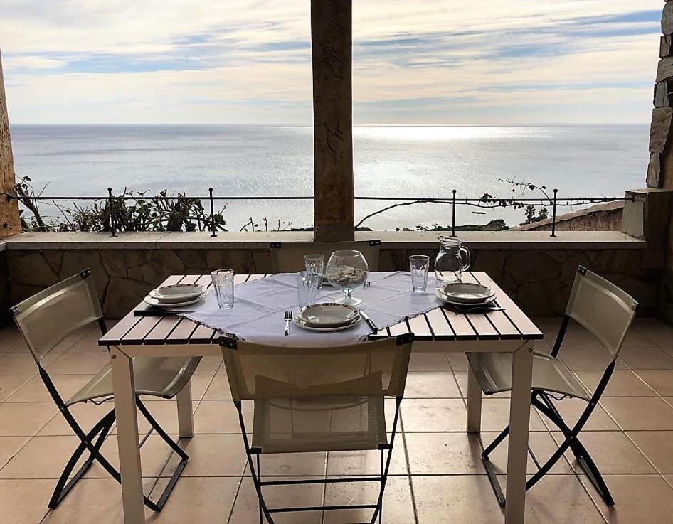 uma mesa e cadeiras com vista para o oceano em Casa Porto Corallo em Villaputzu