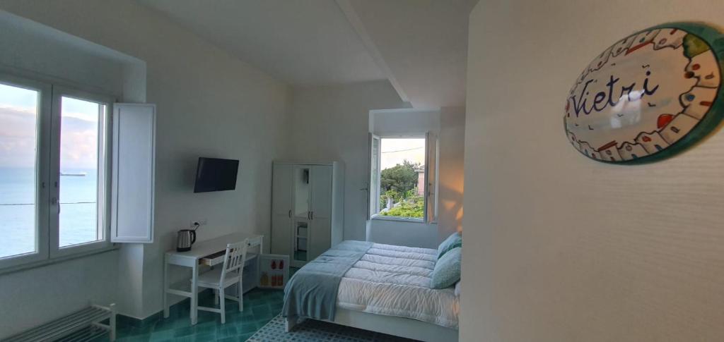 a bedroom with a bed and a desk and a window at B&B FISH in Vietri sul Mare