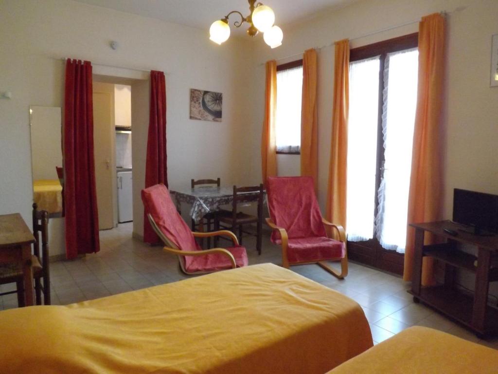 une chambre d'hôtel avec deux lits, une table et des chaises dans l'établissement Studio n°5 agréable et bien situé, à Amélie-les-Bains-Palalda