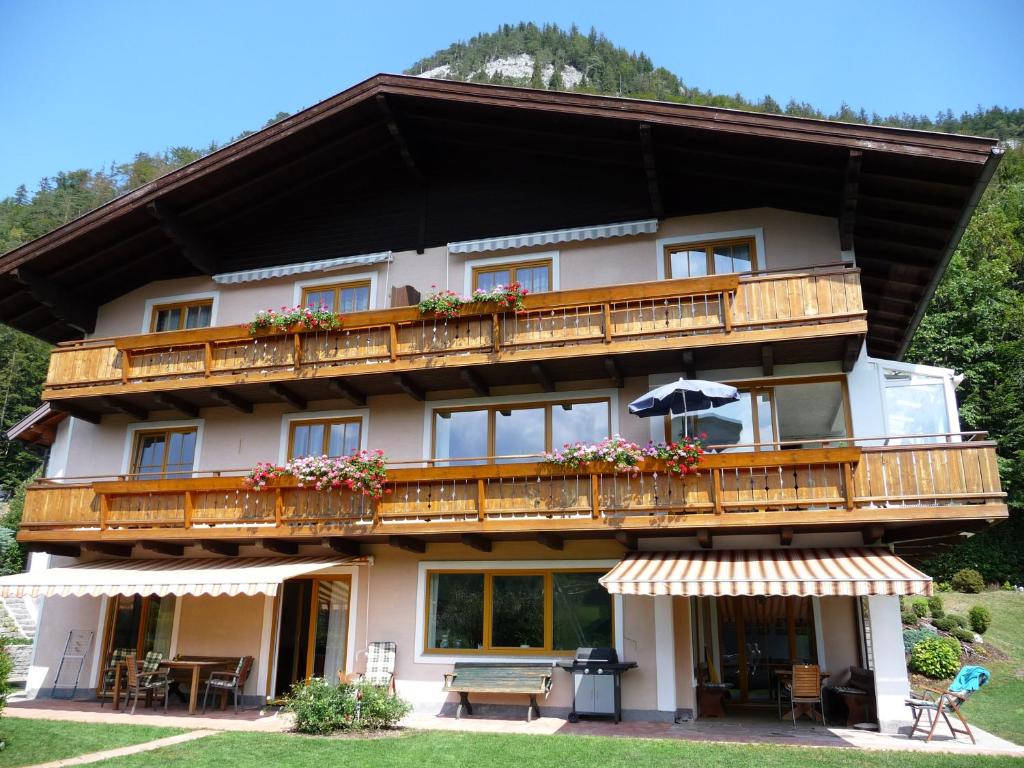 a building with a balcony with tables and an umbrella at Haus Lungau in Fuschl am See