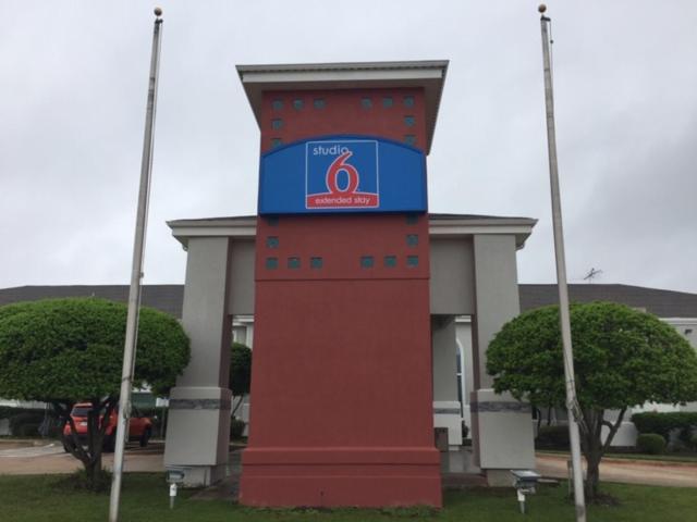 a red and blue tower in front of a building at Studio 6 Burleson in Burleson