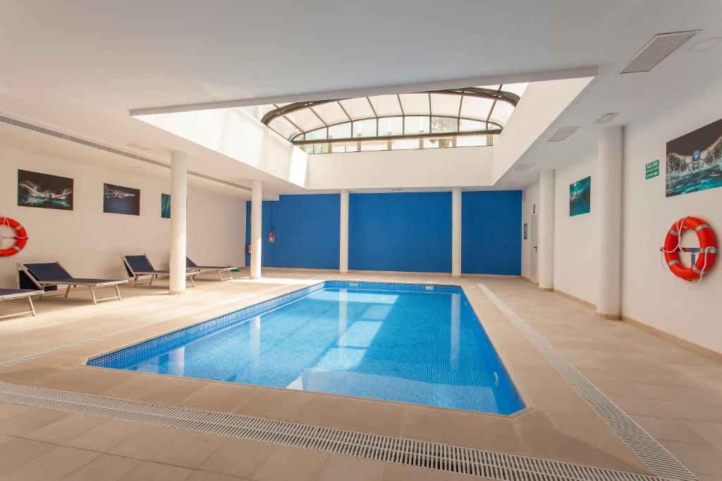a large swimming pool in a building with a ceiling at ApartUP Patacona Beach Select in Valencia