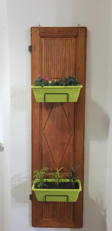 two planters on a wooden wall with plants in them at Defi house in Chianni
