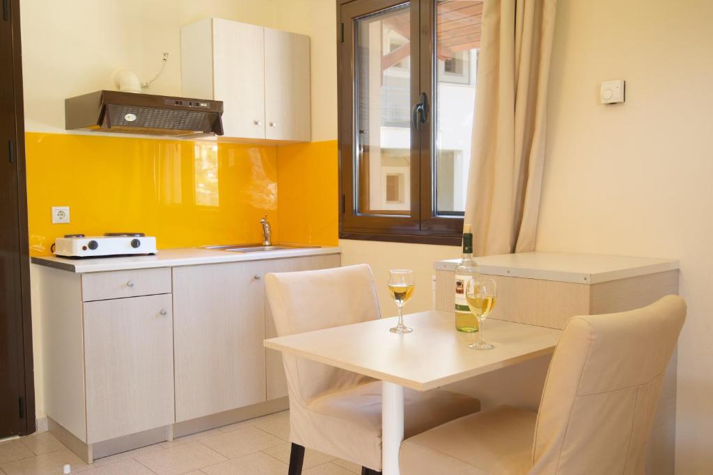a kitchen with a table and two glasses of wine at Minas Apartments in Divarata