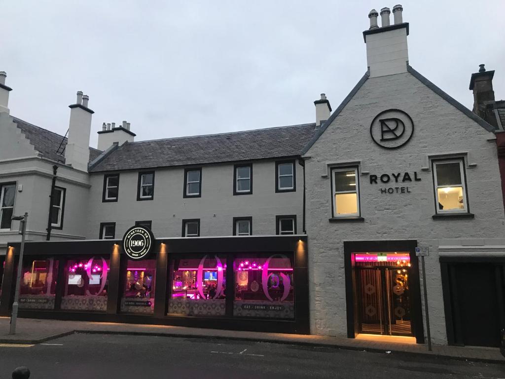 Un bâtiment avec des lumières violettes dans les fenêtres dans l'établissement Royal Hotel, à Cumnock