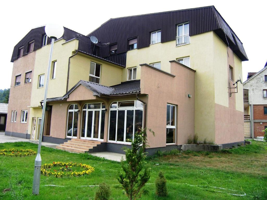a large house with a black roof at Hotel Dulovic in Mojkovac