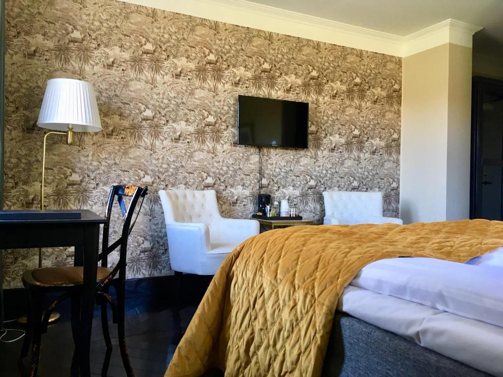 a hotel room with a bed and a tv on a wall at Björnhofvda Gård in Björnhuvud
