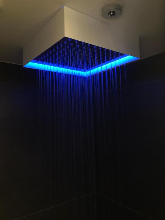 Hotel GRADO24, a blue light above a shower in a bathroom at GRADO24 in Bologna