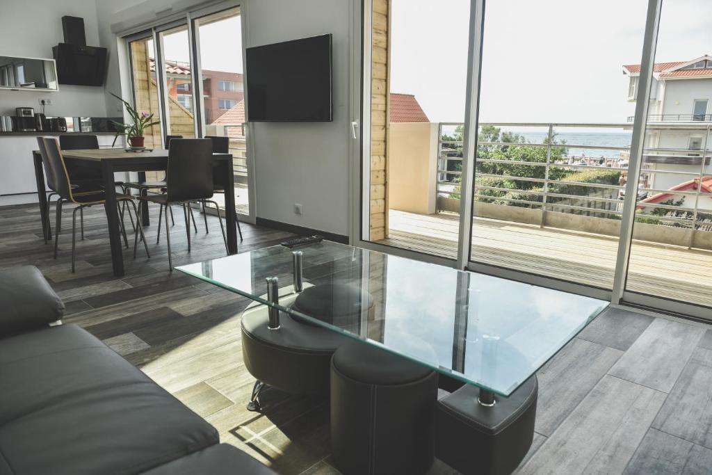 a living room with a glass table and a dining room at BodyGo Penthouse in Capbreton