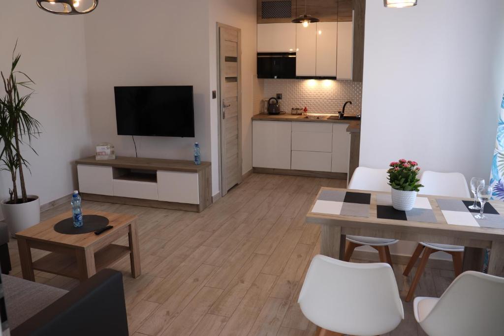 a living room with a table and a kitchen at Apartament Natalia in Busko-Zdrój