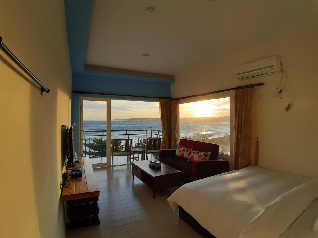 a bedroom with a bed and a view of the ocean at Hearty Homestay in Nanwan