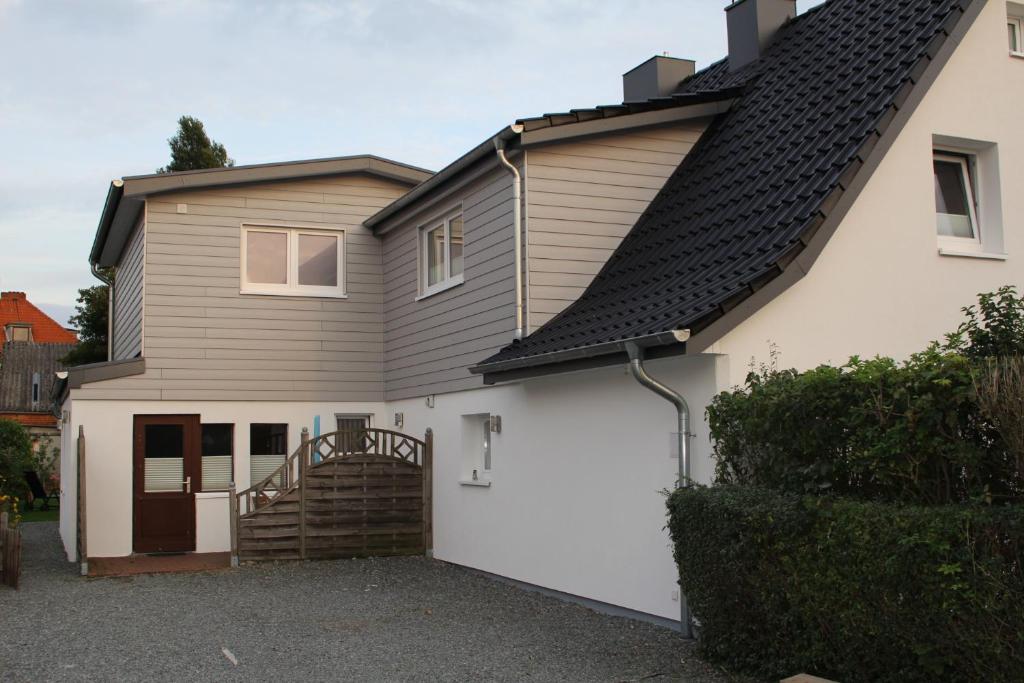 a white house with a black roof at Ferienwohnung 3 in Dahme