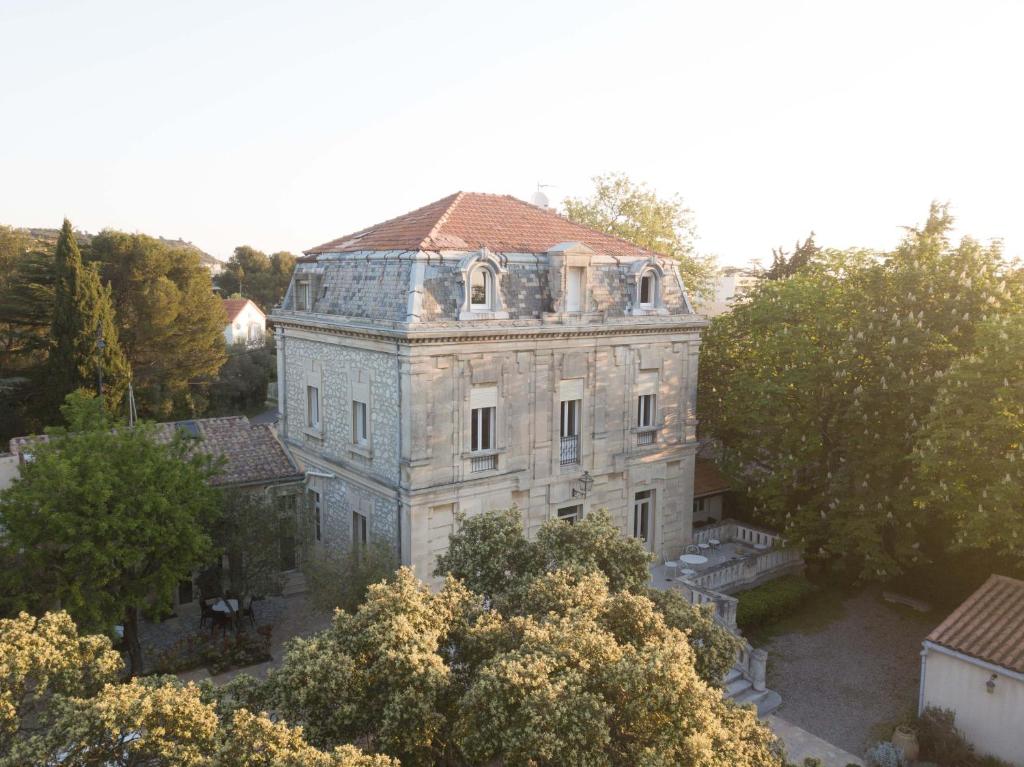 um antigo edifício de pedra com um telhado vermelho em Logis Hôtel Résidence Les Cèdres em Villeneuve-lès-Avignon