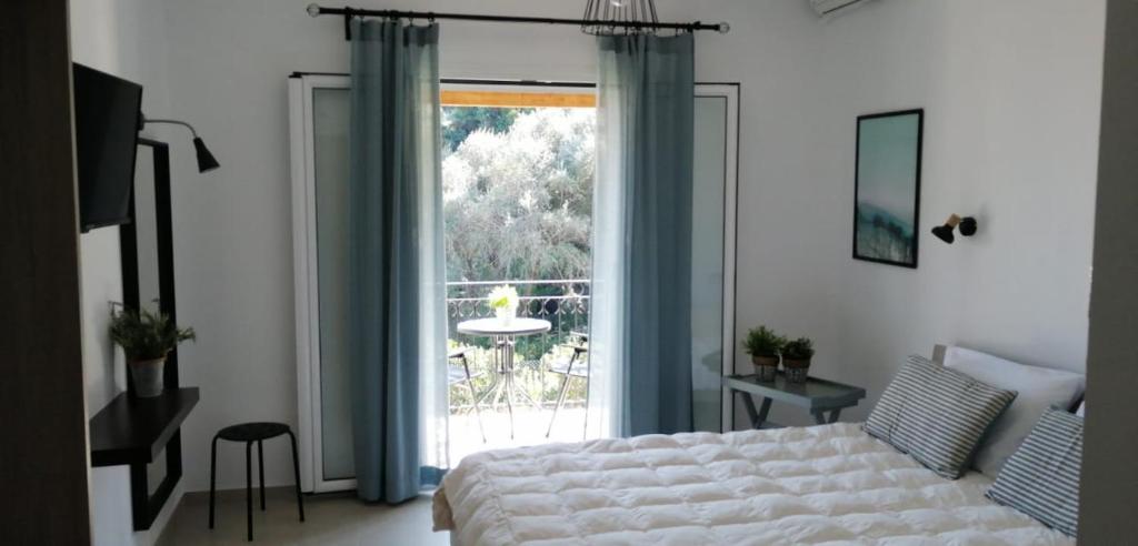 a bedroom with a bed and a large window at Iliana Studios in Benitses