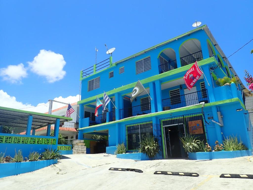 un edificio azul con banderas delante en The Vieques Guesthouse en Vieques