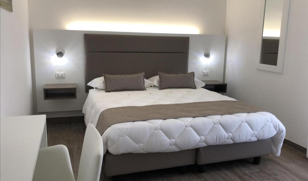 a bedroom with a large white bed with two pillows at La Dimora del Passante in San Vito lo Capo