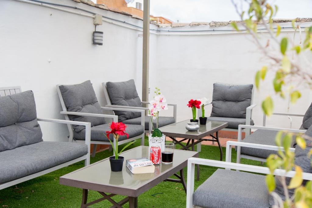 un patio con sofás grises, mesas y flores en Hotel Marbella, en Fuengirola