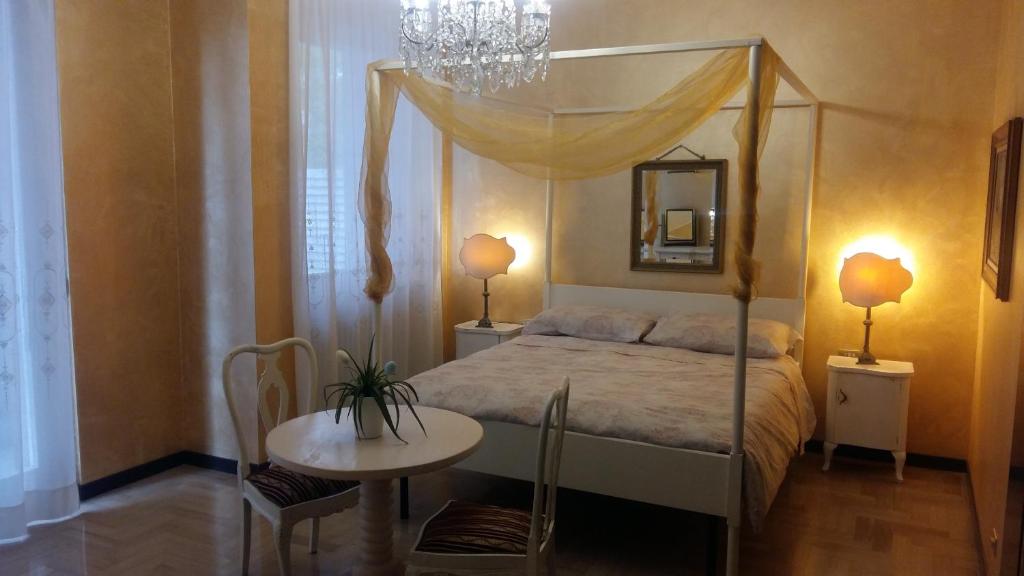 a bedroom with a canopy bed and a table at La Martino B&B in Varese