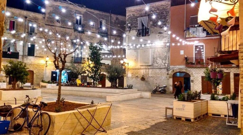 a building with a courtyard with a tree and lights at Macario Apartment in the Old Town in Bari