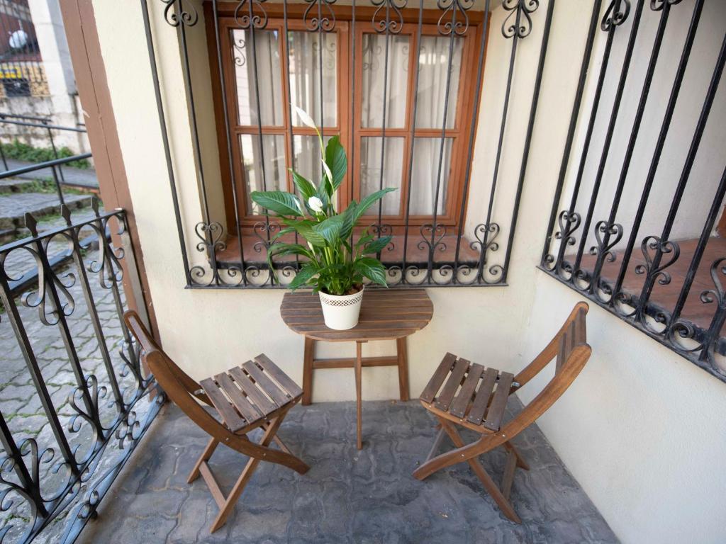 uma varanda com duas cadeiras e uma mesa com um vaso de plantas em Espacios Blanco Plaza del Viejo Coso em Valladolid