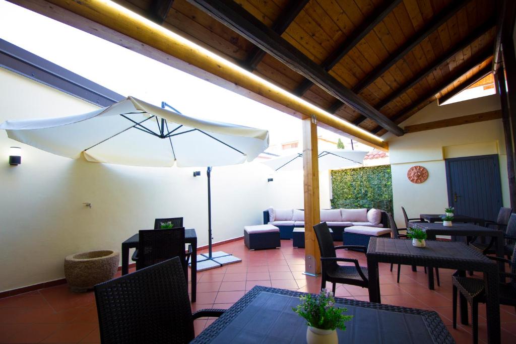 un patio con tavoli, sedie e ombrellone di Guest House Capitan Libeccio a Tropea