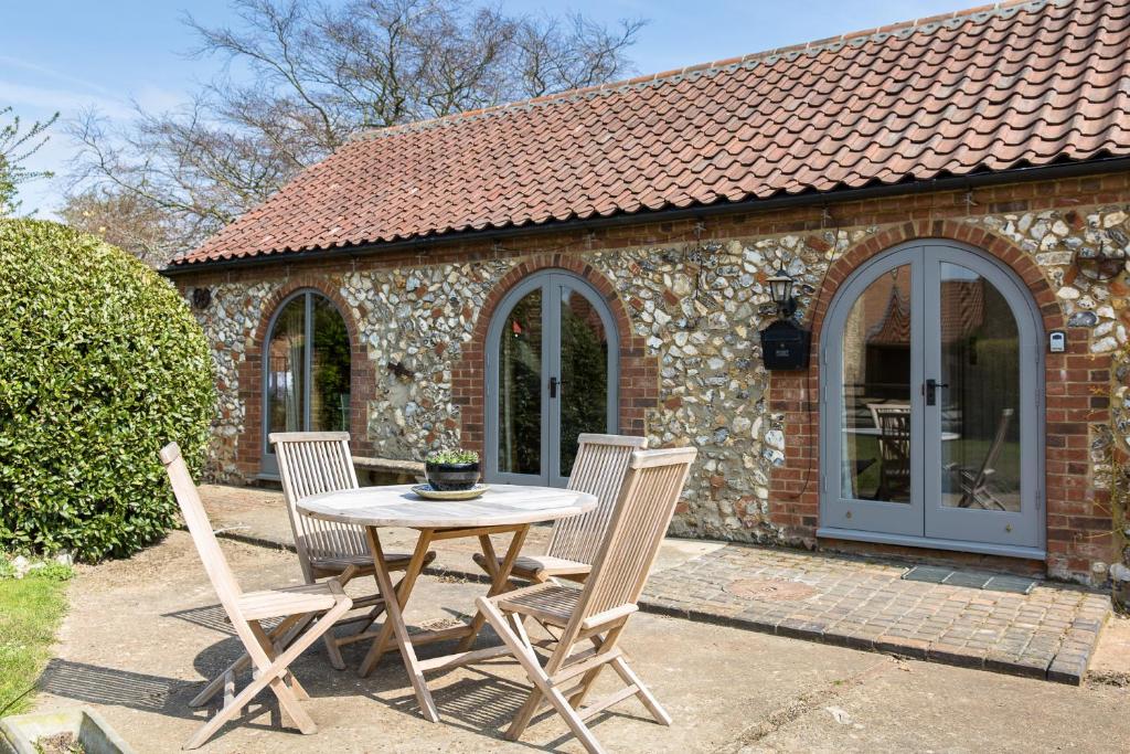 a table and chairs in front of a brick building at The Old Stables in Docking