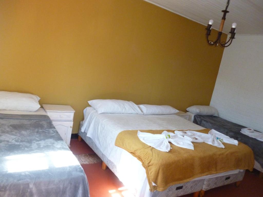 a bedroom with two beds with towels on them at Passaros Suite Hotel in Puerto Iguazú