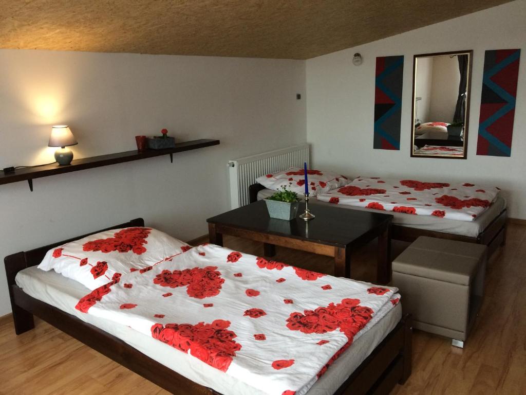two beds in a room with red flowers on them at Stara Kuźnia in Sztutowo
