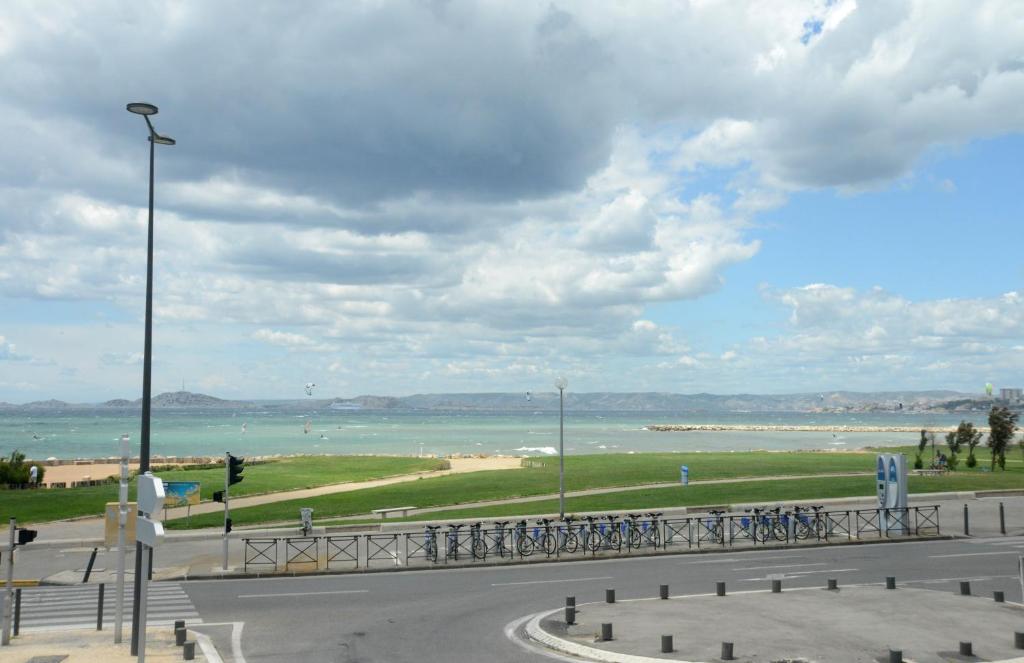 a road with bikes parked next to the ocean at Hôtel Le Mistral in Marseille