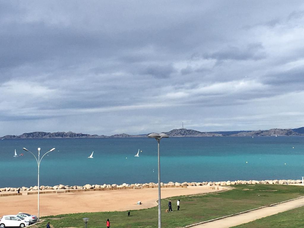 Blick auf einen Strand mit Booten im Wasser in der Unterkunft Hôtel Le Mistral in Marseille