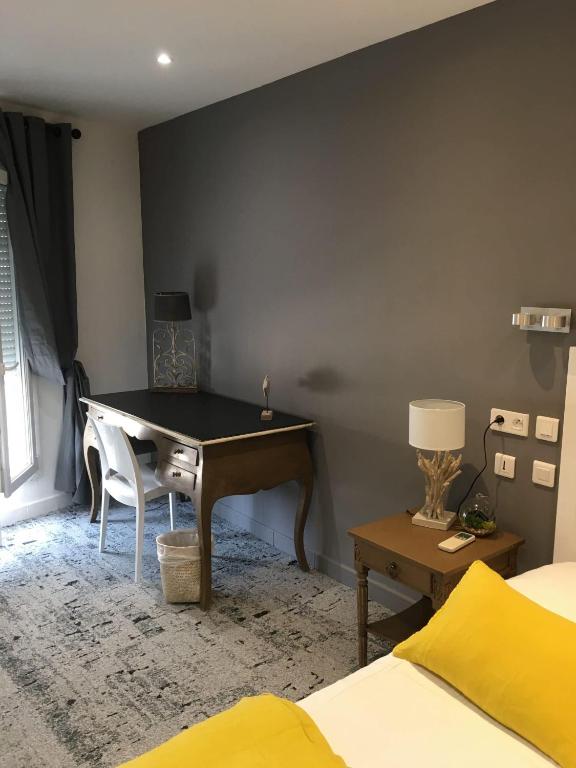 a desk in a bedroom with a bed and a desk at Hôtel Le Mistral in Marseille