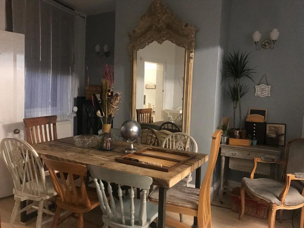 a dining room with a table and a mirror at BEAUTIFUL TERRACE COTTAGE HOME, 3 BEDROOM HOUSE near Alton Towers, LEEK Centre, Peak District on doorstep in Leek