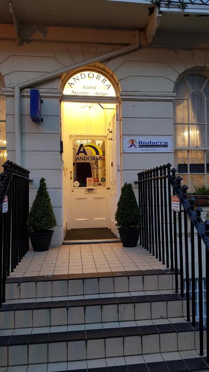 a white door of a building with two plants at Andorra Guest Accommodation in Brighton & Hove