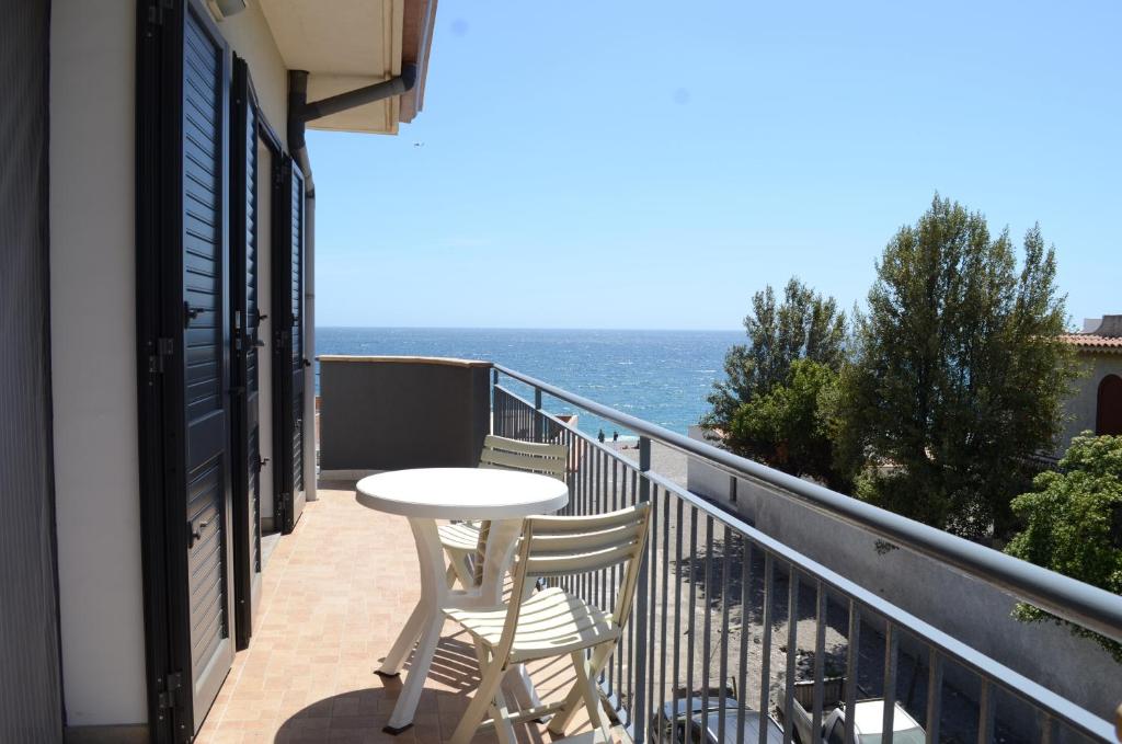 einen Balkon mit einem Tisch, Stühlen und Meerblick in der Unterkunft Santanna Beach House - Fondachello-apartments com in Mascali
