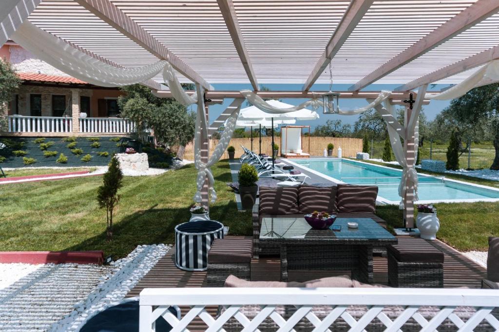 a backyard with a pergola and a swimming pool at Fokas Luxury Villa in Prinos