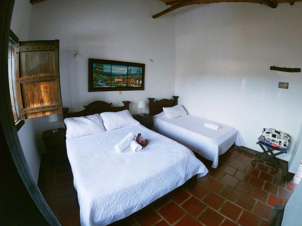 1 dormitorio con 2 camas con sábanas blancas en Hotel Casa Claustro De Zapatoca, en Zapatoca