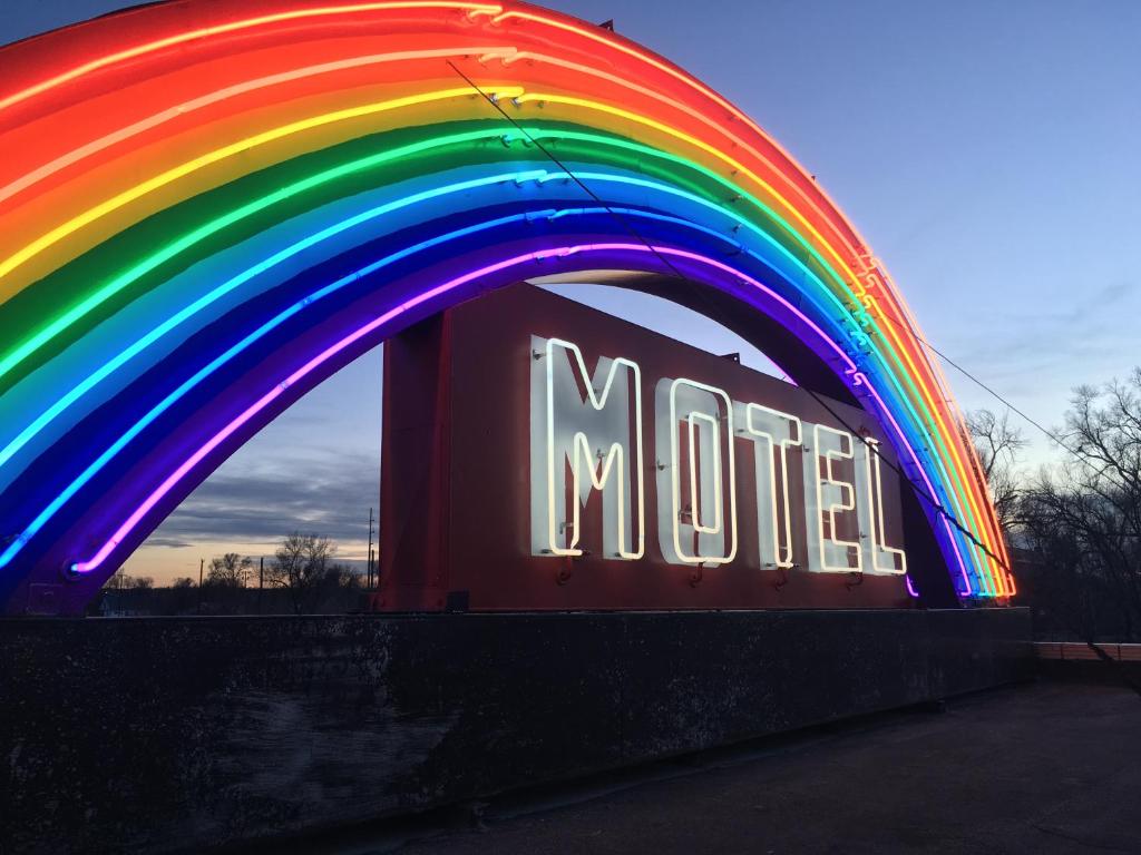 Rainbow Motel في غريلي: علامة نيون مع قوس قزح فوق علامة المترو