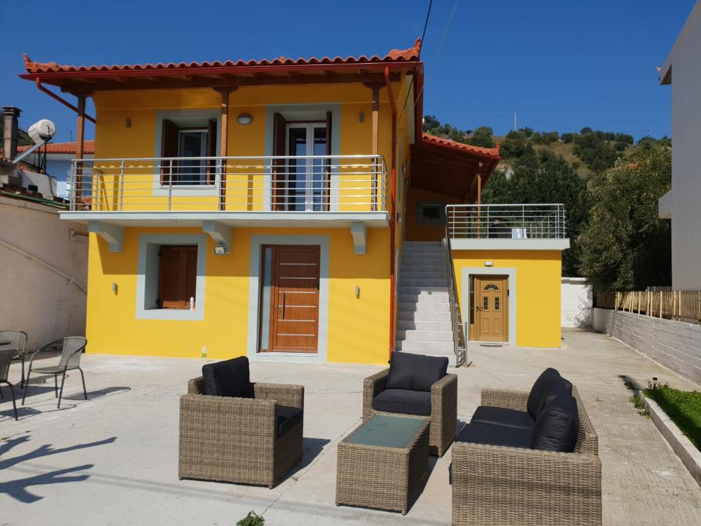 a yellow house with furniture in front of it at Villa Matina in Sampatiki