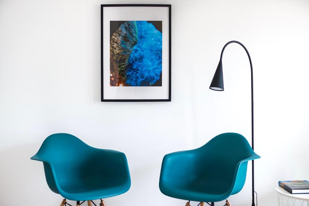 um quarto com duas cadeiras azuis e um candeeiro em vilamaria apartment em Porches