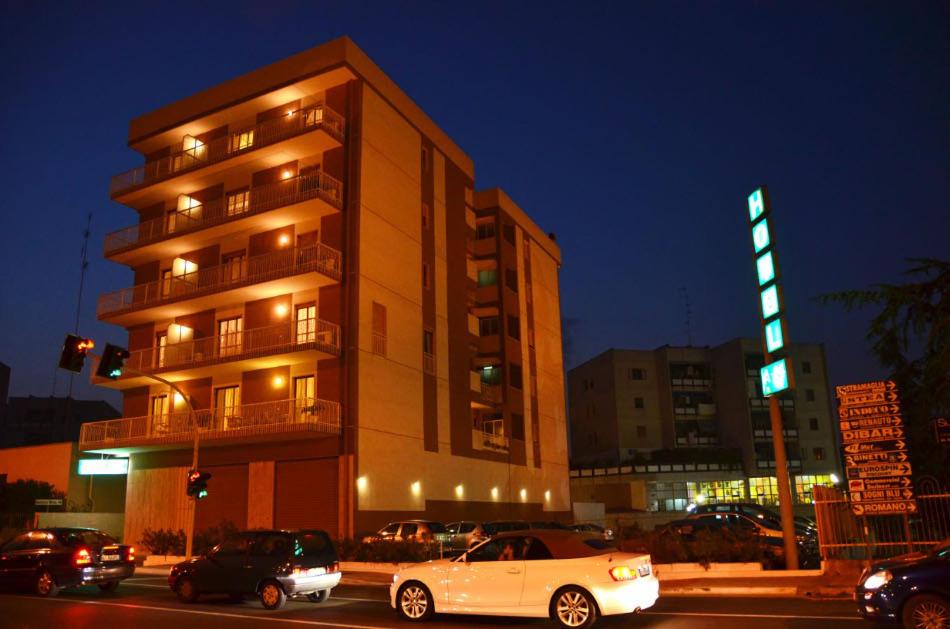 un edificio con coches aparcados delante de él por la noche en Hotel A-14, en Modugno
