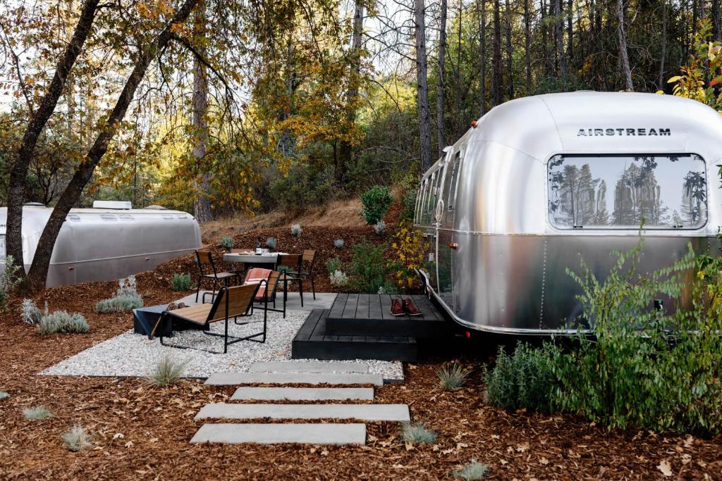 an rv parked in a garden with a table and chairs at AutoCamp Yosemite in Midpines
