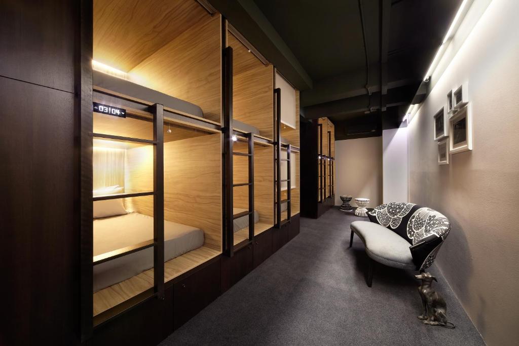 a room with a bed and a chair in it at The Pod at Beach Road Boutique Capsule Hotel in Singapore