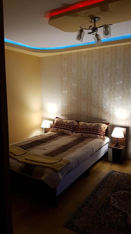 a bedroom with a bed with two lamps on it at Near center in Petroşani