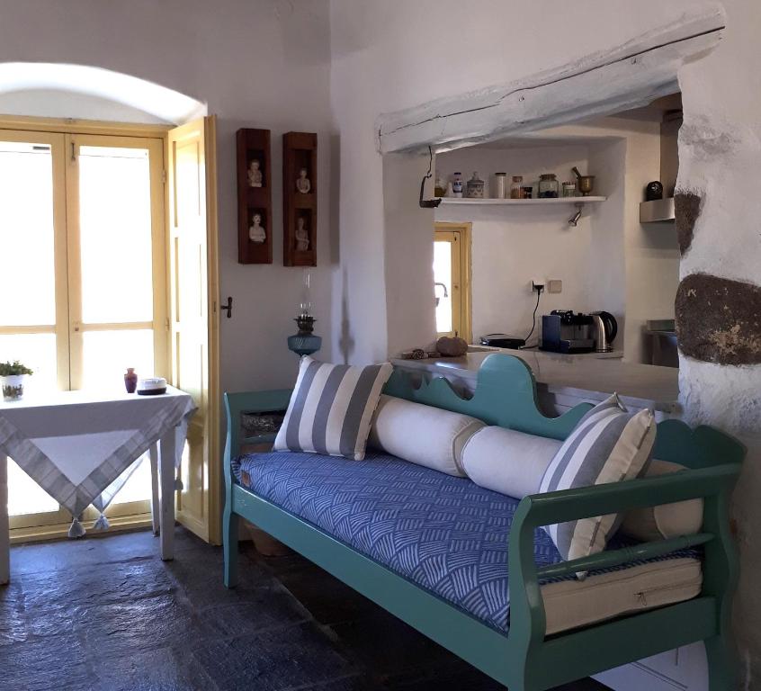 Un dormitorio con un sofá azul con almohadas. en Open Space House at the Castle of Chora, Serifos, en Serifos Chora