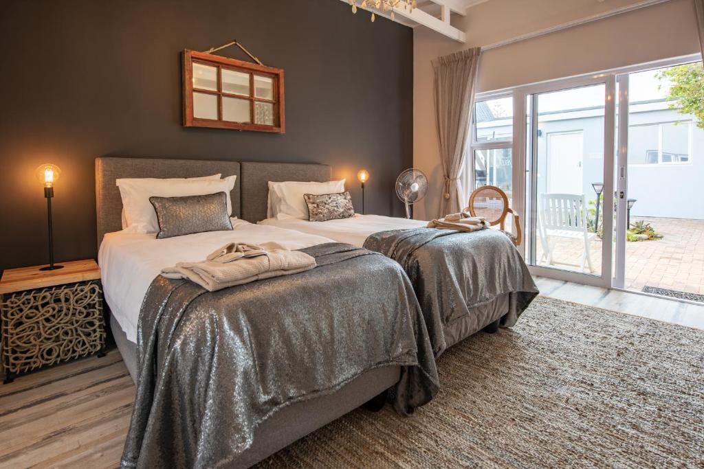una camera con due letti e una grande finestra di SALT Boutique Guesthouse a Bloubergstrand